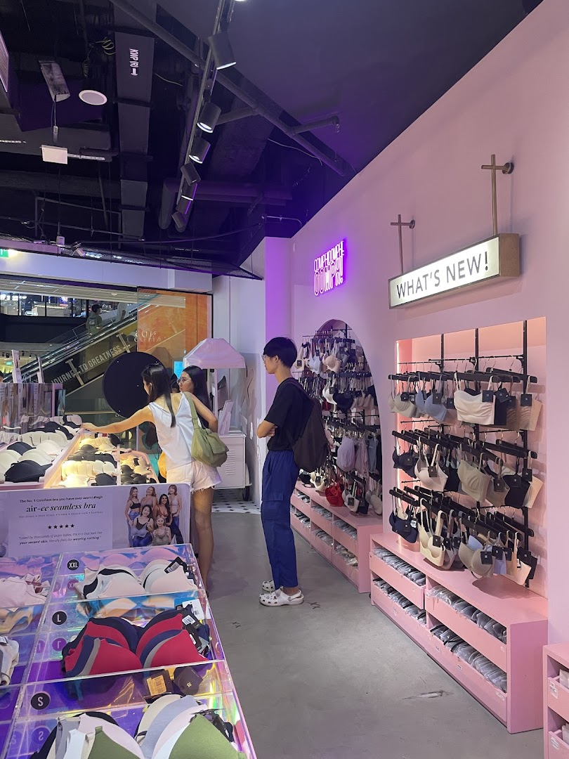 Customers browse comfortable and stylish lingerie in a modern, pink-themed shop interior.