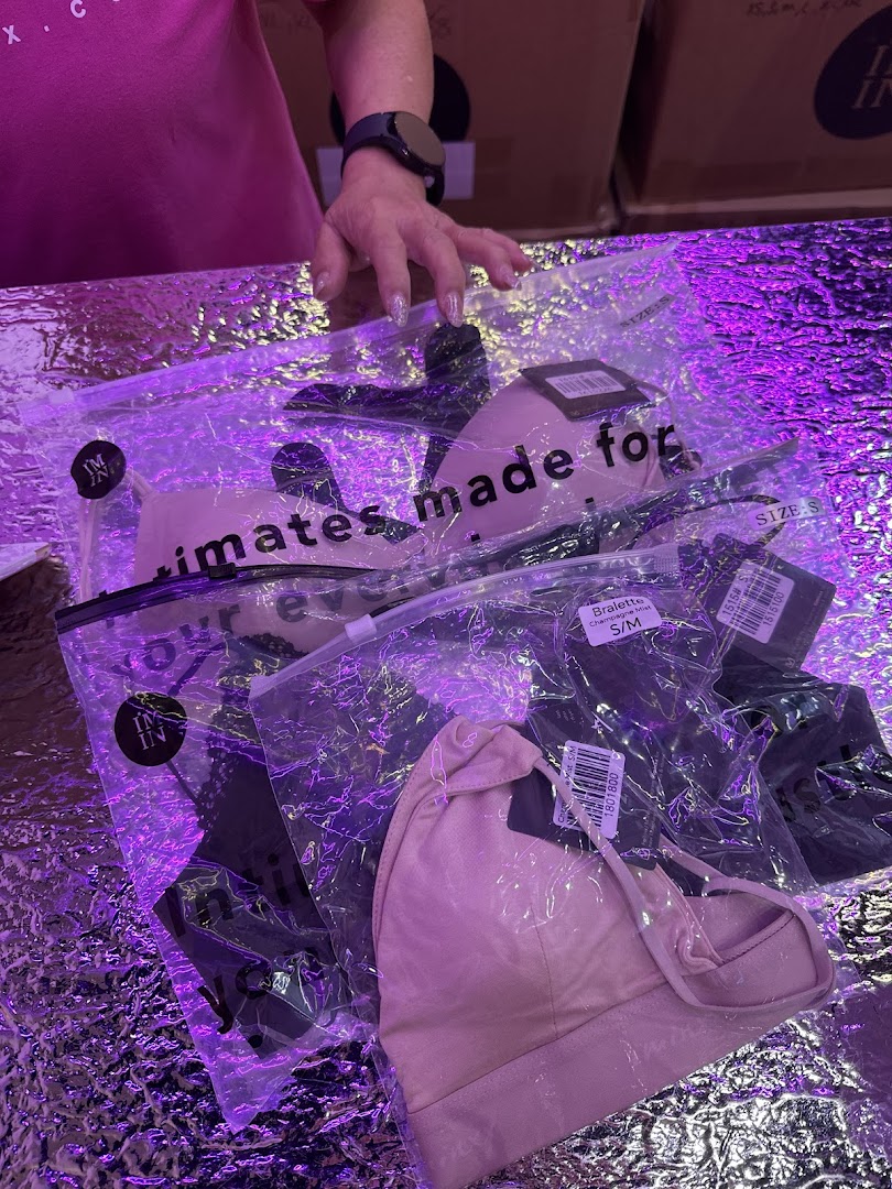Packaged intimates and bralettes from IM IN IMINXX displayed on a reflective surface.