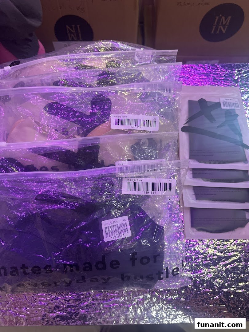 Packaged apparel items in various colors, including 'Almond Nude' and 'Midnight Blue', displayed under purple lighting.
