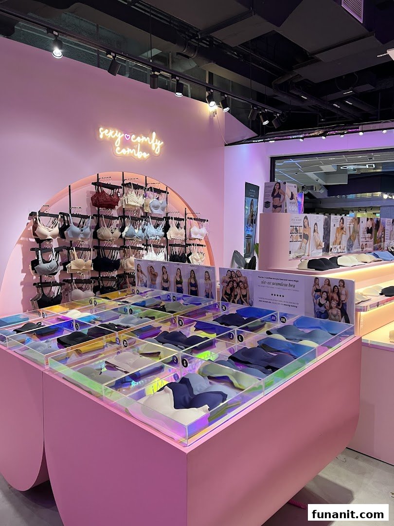 Vibrant pink lingerie shop interior showcasing bras on display racks and in organized bins.