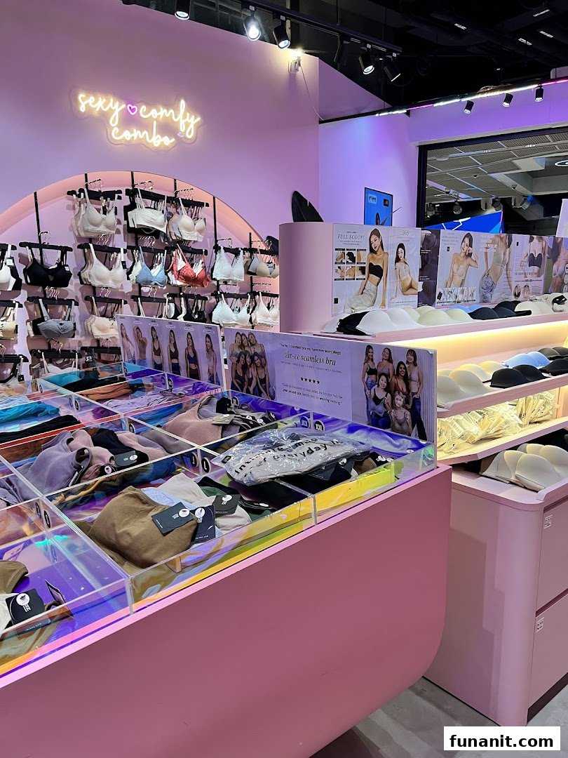 Interior view of a vibrant lingerie and apparel shop with pink decor and product displays.