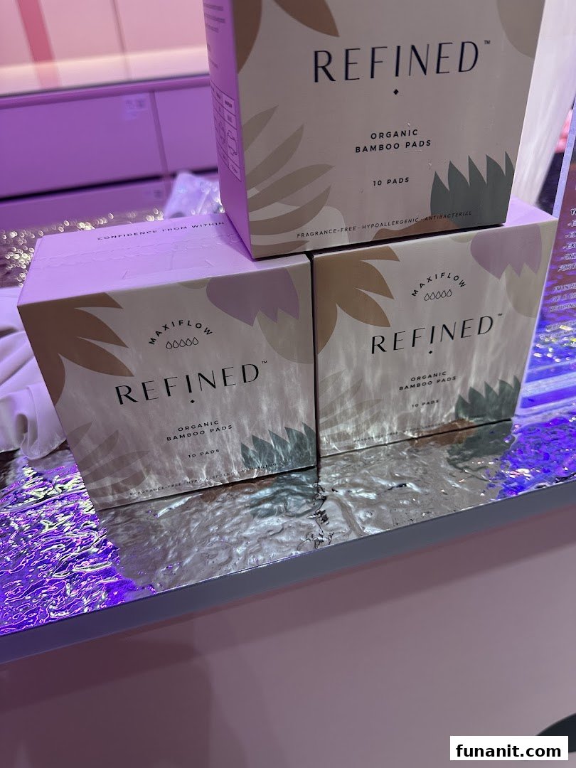 Close-up of REFINED Organic Bamboo Pads boxes displayed on a reflective surface.