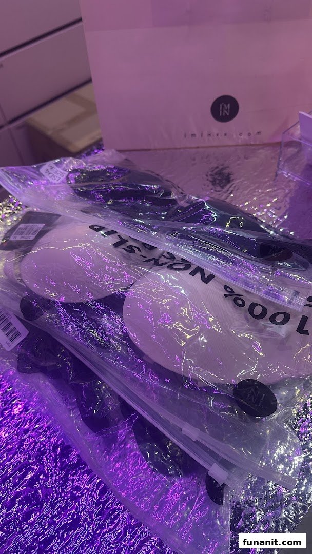 Packaged lingerie accessories, possibly bra inserts, displayed under purple lighting from IM IN IMINXX.