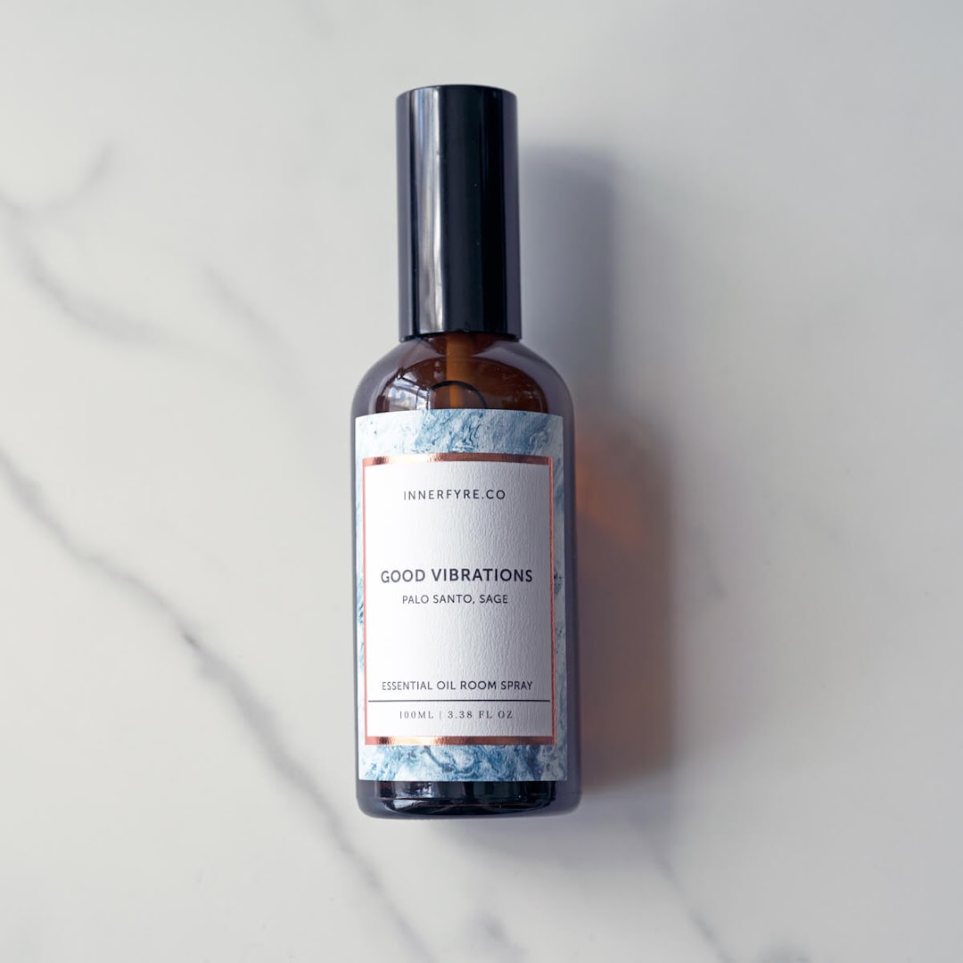 A bottle of Innerfyre Co's 'Good Vibrations' essential oil room spray on a marble surface.