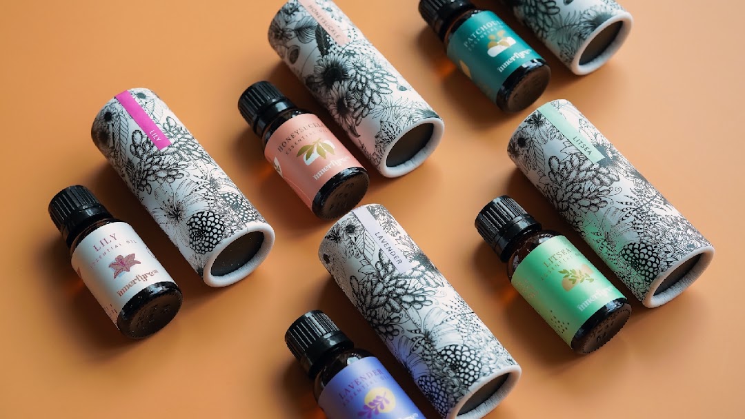 A collection of Innerfyre Co essential oil bottles and their decorative packaging.