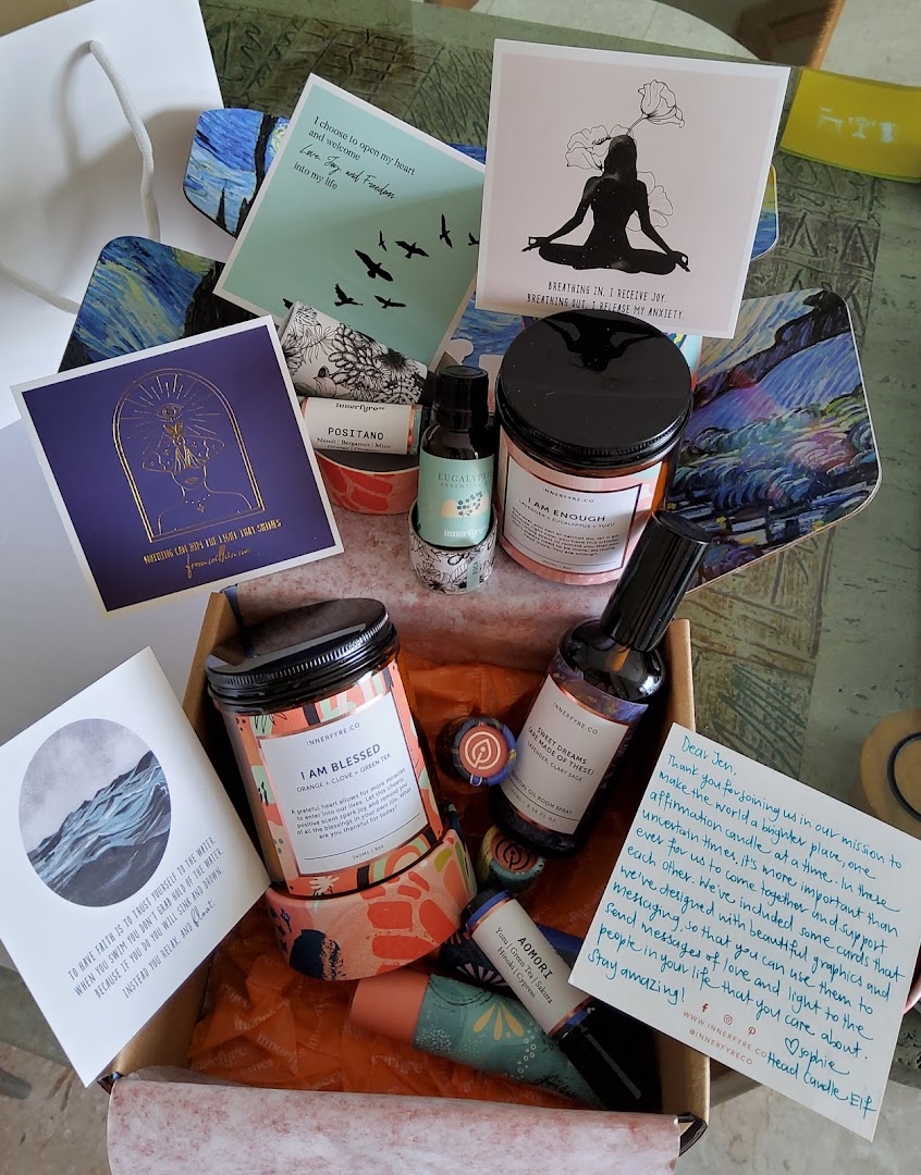 A curated box of Innerfyre Co. wellness products, including affirmation candles, essential oils, and inspirational cards.