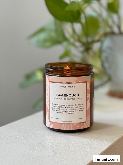 A close-up of an Innerfyre Co. 'I Am Enough' candle with lavender, eucalyptus, and yuzu scents.