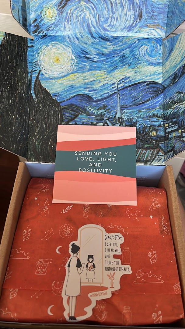 An open Innerfyre Co box revealing a Starry Night lid, a positive message card, and a product wrapped in red tissue paper.