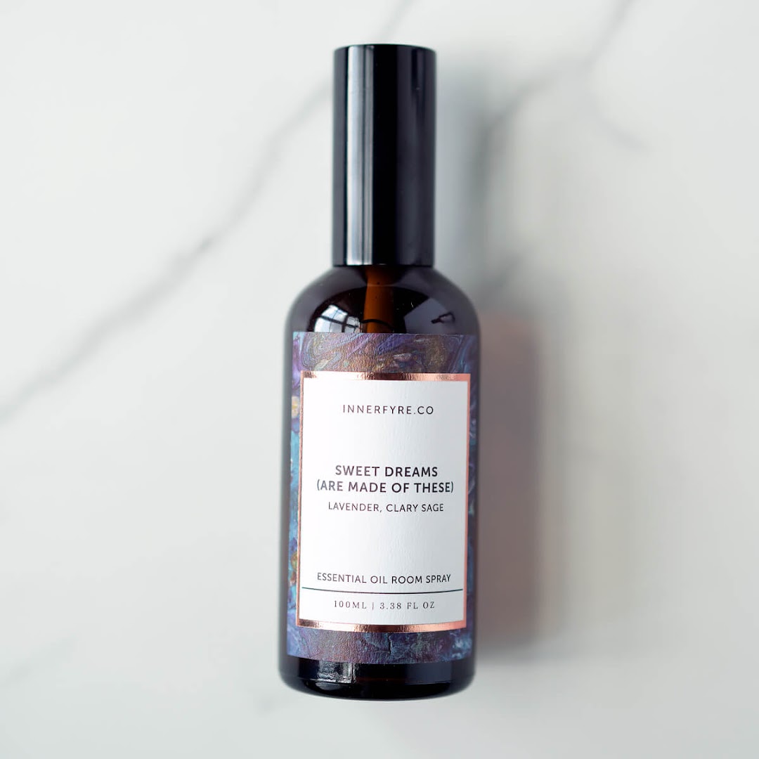 A bottle of Innerfyre Co's 'Sweet Dreams' essential oil room spray on a marble surface.