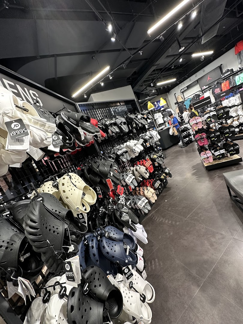 An interior shot of JD Sports showcasing a wide variety of footwear, including Crocs, sandals, and slides.