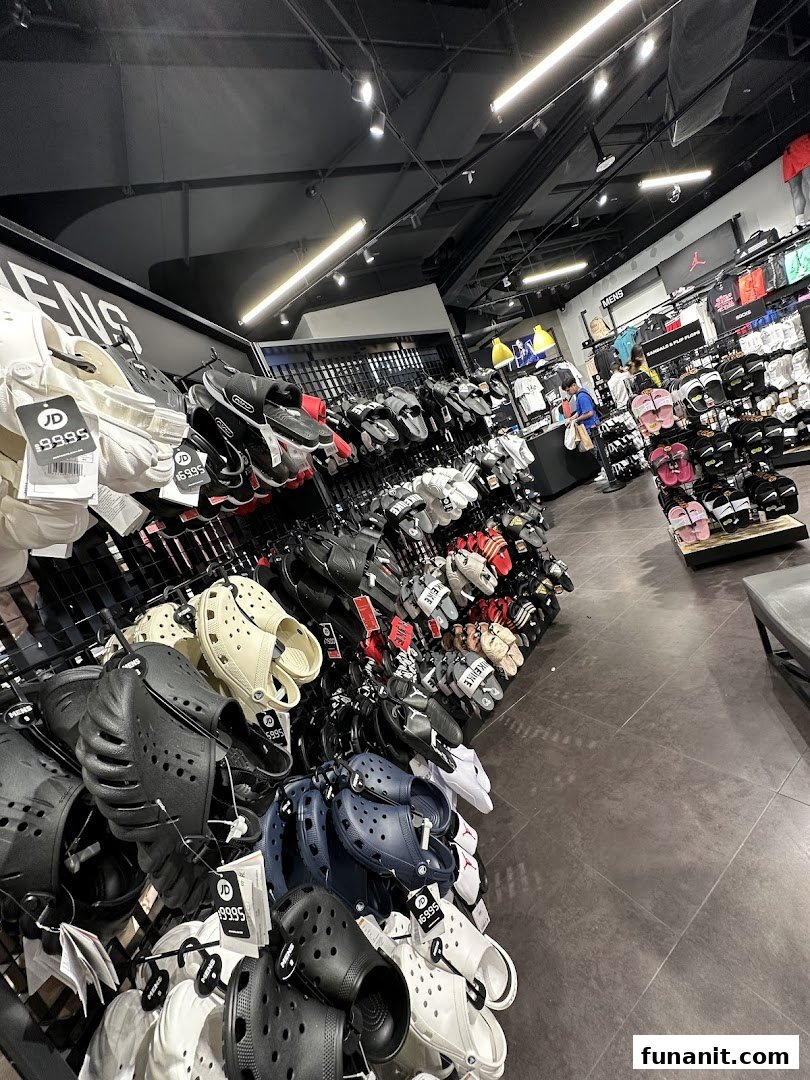 An interior shot of JD Sports showcasing a wide variety of footwear, including Crocs, sandals, and slides.
