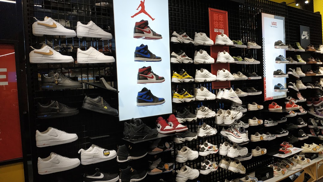 A vibrant display of athletic footwear, featuring popular sneakers from various brands like Nike, Jordan, and Vans.