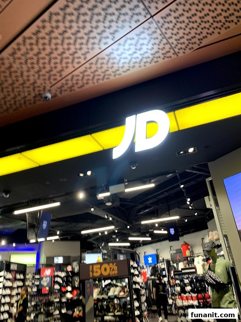 The entrance of JD Sports, showcasing its prominent logo and a view into the vibrant retail space.