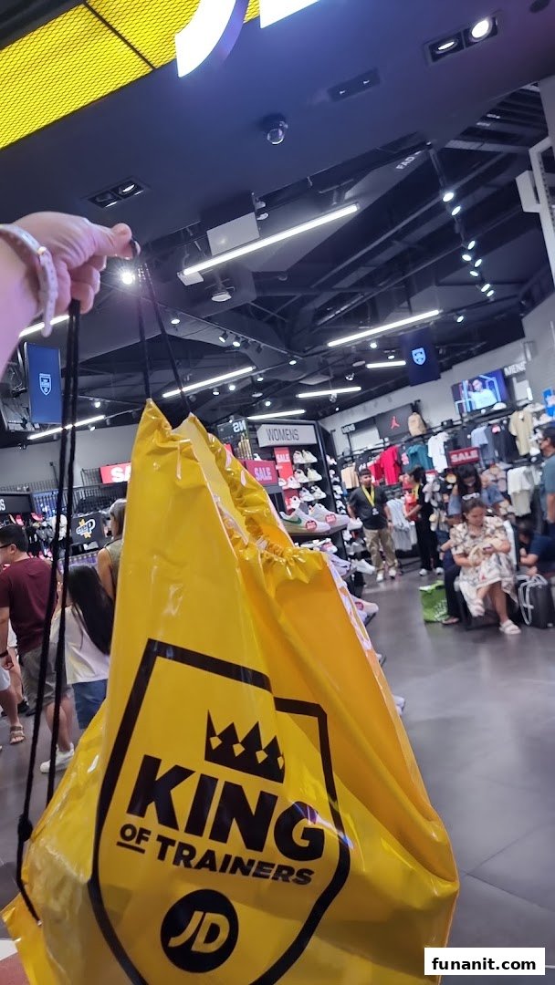 Interior view of JD Sports with customers and a prominent 'King of Trainers' shopping bag.