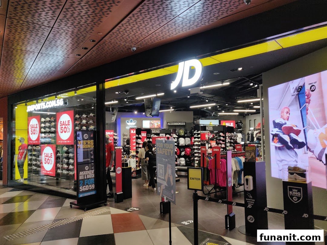 The vibrant storefront of JD Sports showcases athletic footwear, apparel, and accessories with prominent sale signage.