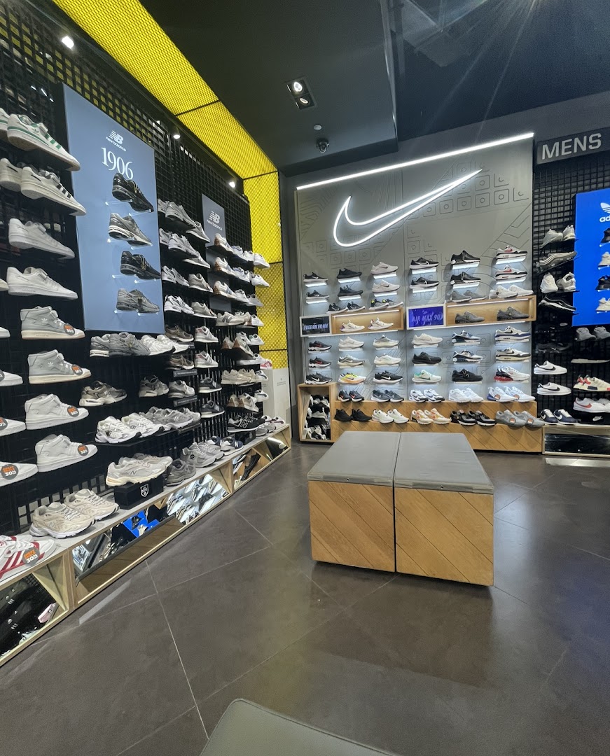 An interior view of JD Sports showcasing a wide array of athletic footwear from various brands like Nike and New Balance.