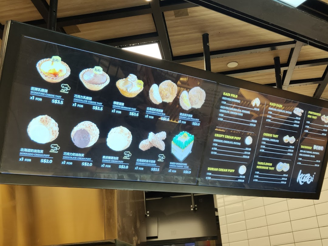 A digital menu board displaying various pastries, tarts, and cream puffs with prices at Kazo.