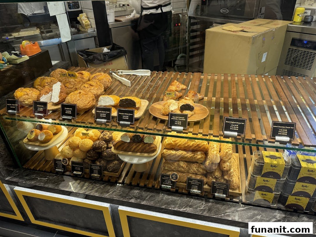 A vibrant display counter at Kazo bakery, showcasing a variety of freshly baked pastries, tarts, and puffs.