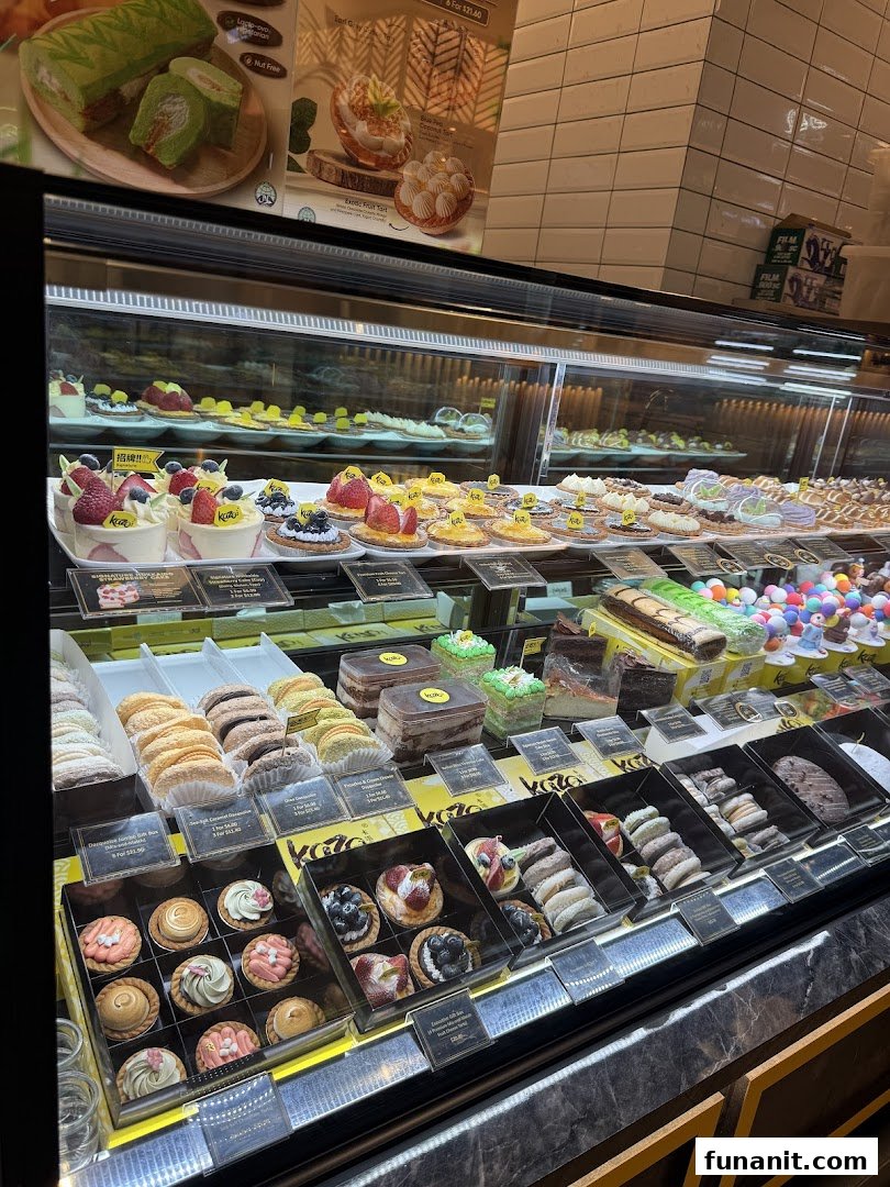 A vibrant display case filled with an assortment of delicious cakes, pastries, and tarts at Kazo.
