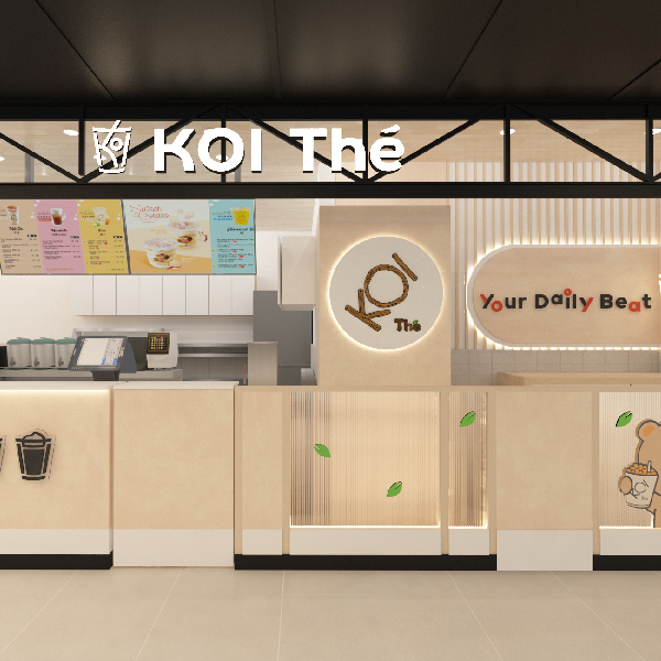 A bright, modern interior view of KOI Thé's service counter with menu boards and brand signage.