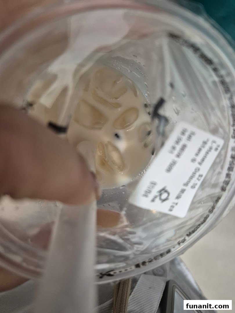 Close-up view of a refreshing bubble tea drink with ice and pearls, featuring a straw.