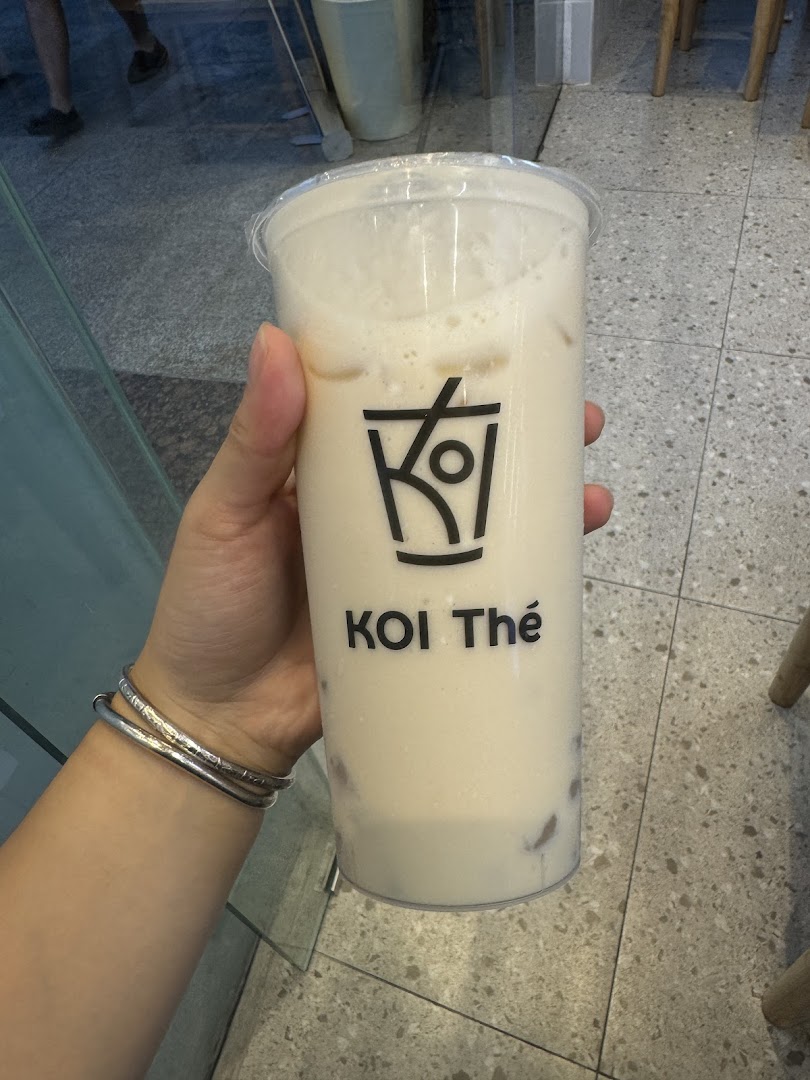 A hand holding a refreshing bubble tea drink from KOI Thé.
