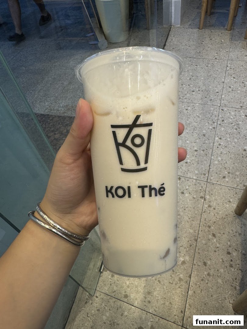 A hand holding a refreshing bubble tea drink from KOI Thé.