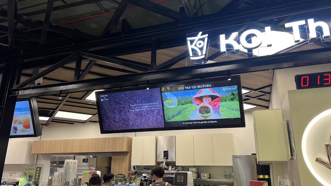 View of the KOI Thé counter area featuring digital displays promoting Uji Matcha and the shop's branding.