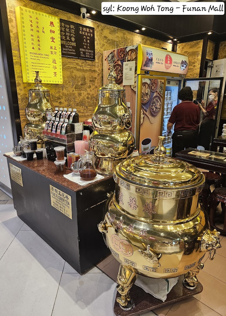Interior view of Koong Woh Tong, showcasing traditional golden herbal tea dispensers and product displays.