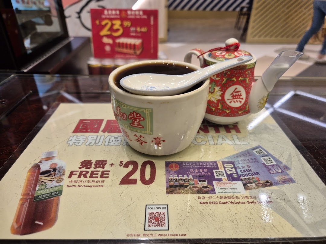 A close-up of Koong Woh Tong's traditional herbal jelly and tea, with promotional offers visible on the table.