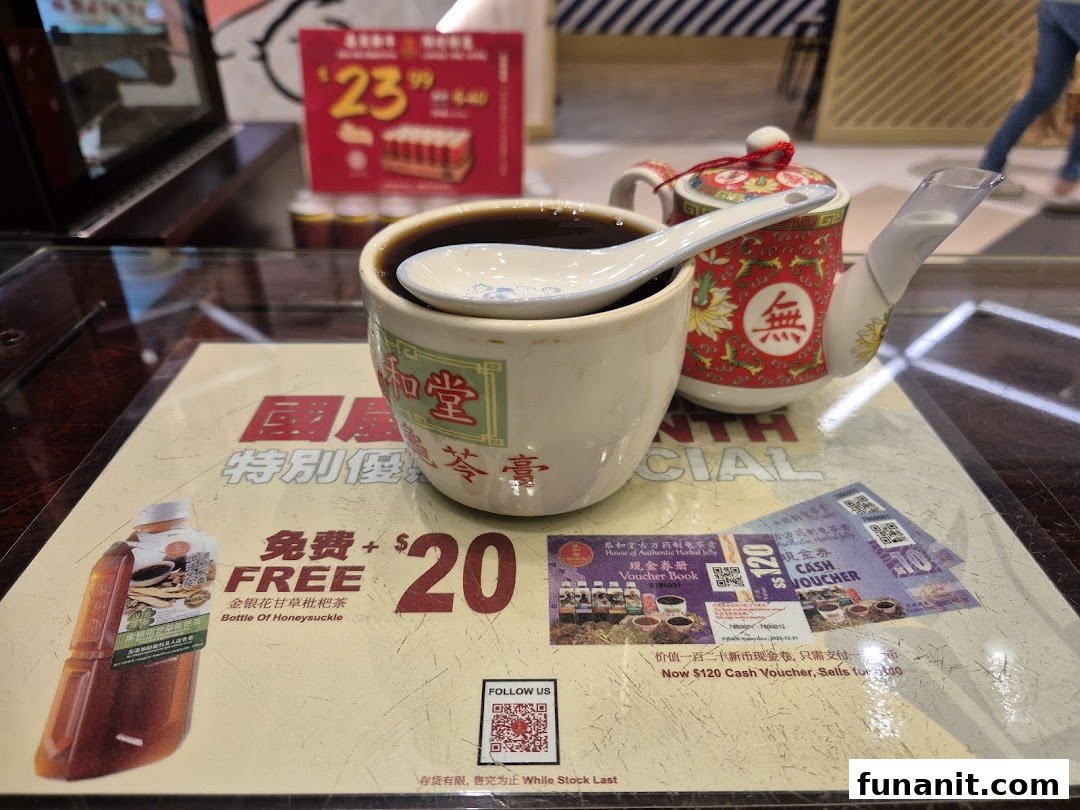 A close-up of Koong Woh Tong's traditional herbal jelly and tea, with promotional offers visible on the table.