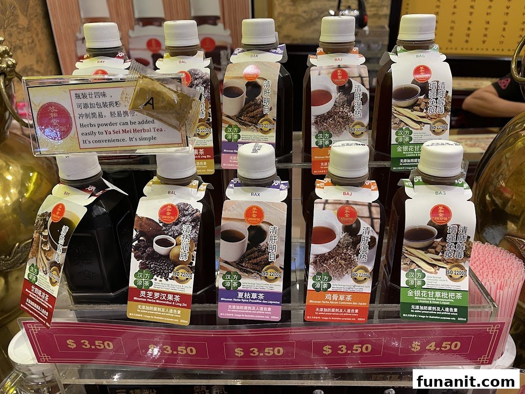 A display of various bottled traditional Chinese herbal drinks with prices at Koong Woh Tong.
