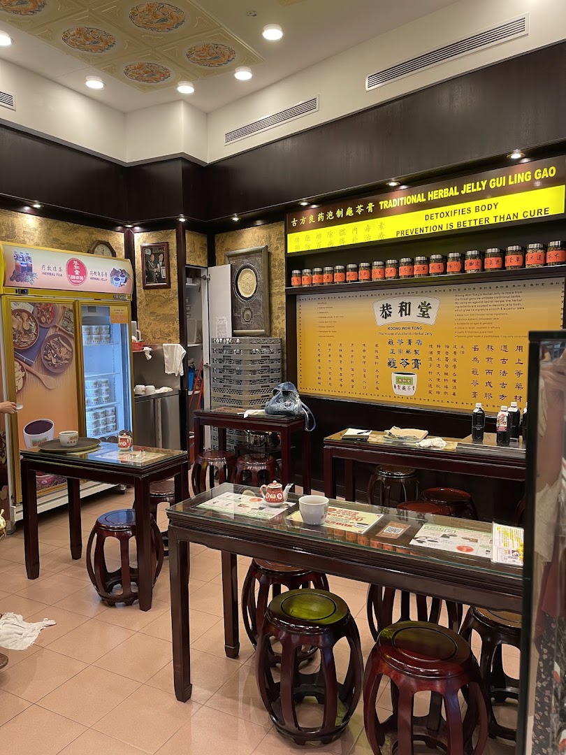 Interior view of Koong Woh Tong, a traditional herbal jelly shop, featuring seating, product displays, and a refrigerator.
