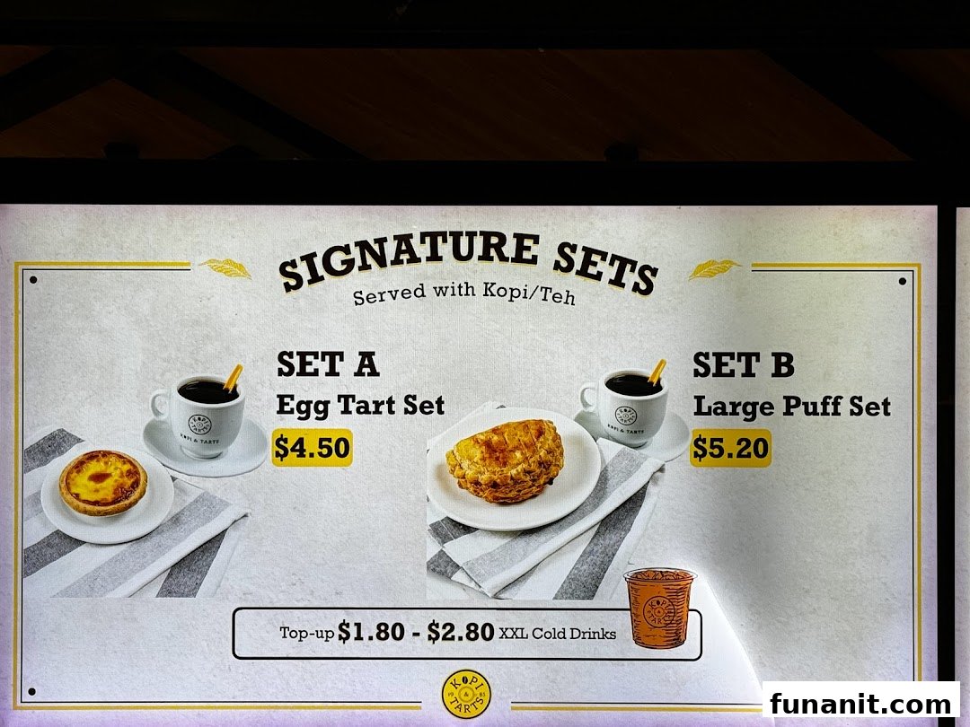 A menu board displaying Kopi Tarts' signature sets, including egg tart and large puff options.