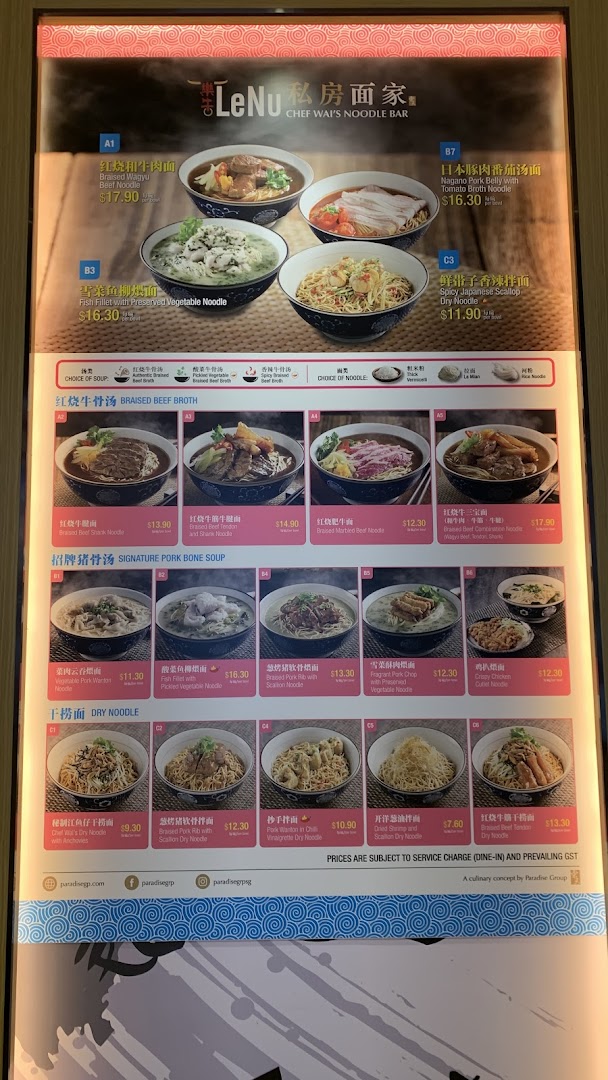 A brightly lit menu board displaying various noodle dishes and prices from LeNu Chef Wai's Noodle Bar.