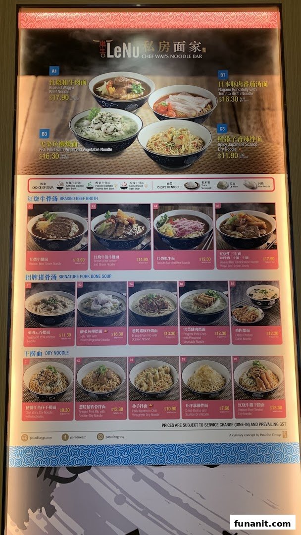 A brightly lit menu board displaying various noodle dishes and prices from LeNu Chef Wai's Noodle Bar.