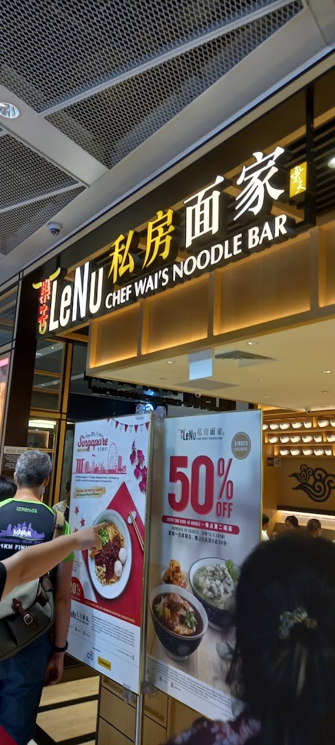 Exterior view of LeNu Chef Wai's Noodle Bar entrance with promotional posters and customers.