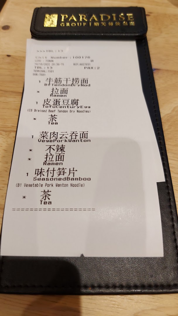 A close-up of an order chit from LeNu Chefs Wai Noodle Bar, showing ordered items.