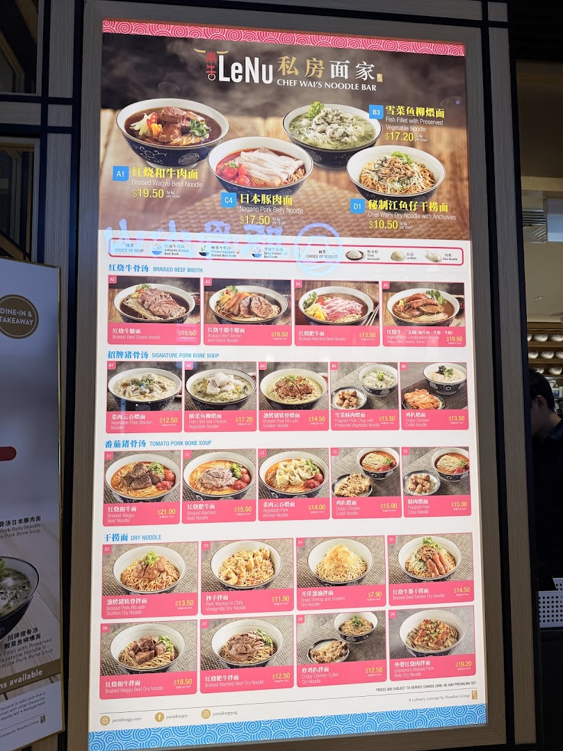A brightly lit digital menu board showcasing various noodle dishes and prices at LeNu Chef Wai's Noodle Bar.