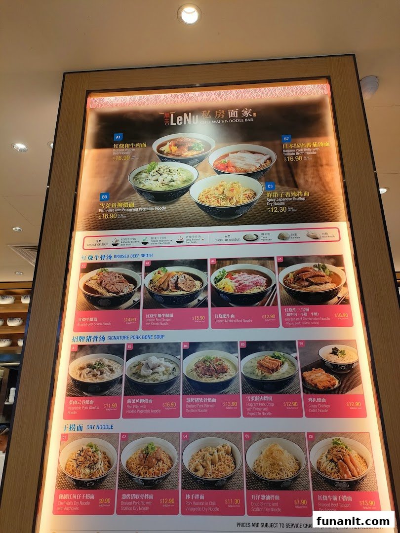 A brightly lit digital menu board displaying various noodle dishes with images and prices.