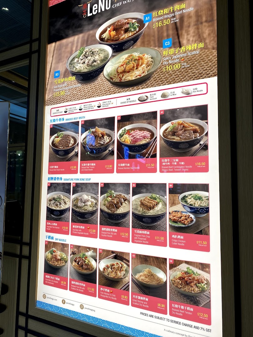 A brightly lit digital menu board showcasing various noodle dishes with prices and images.