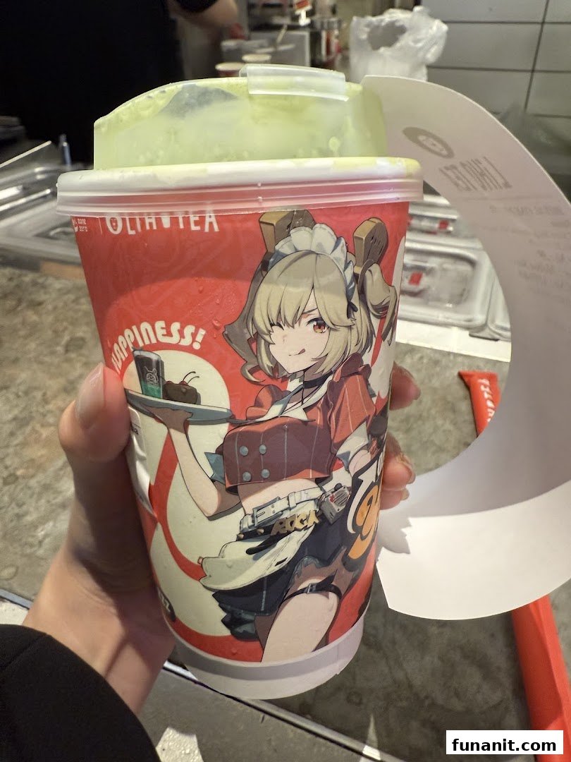 A hand holds a LiHO TEA cup featuring a unique anime character design and a green-colored drink.