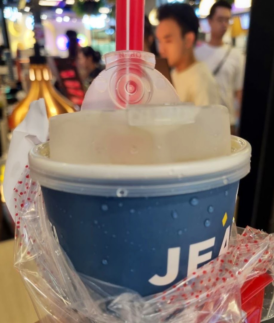 Close-up of a refreshing beverage cup with a straw, held in a plastic bag.