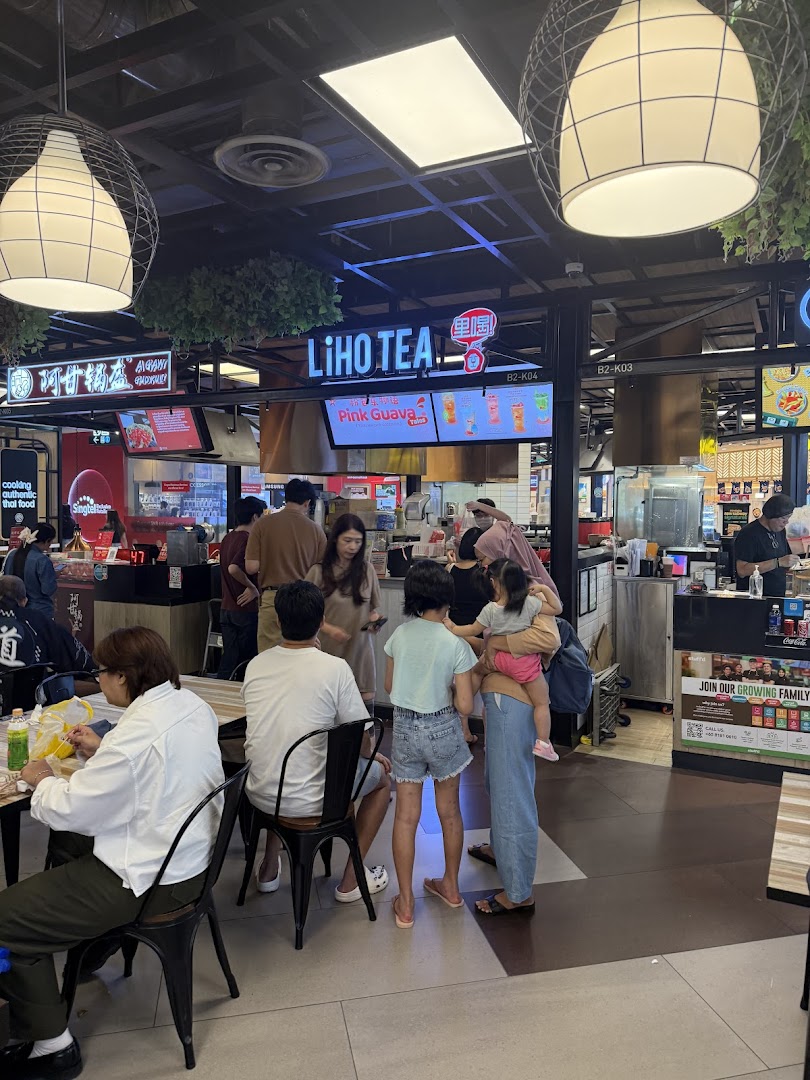LiHO TEA counter with digital menu displays and customers in a busy mall food court.