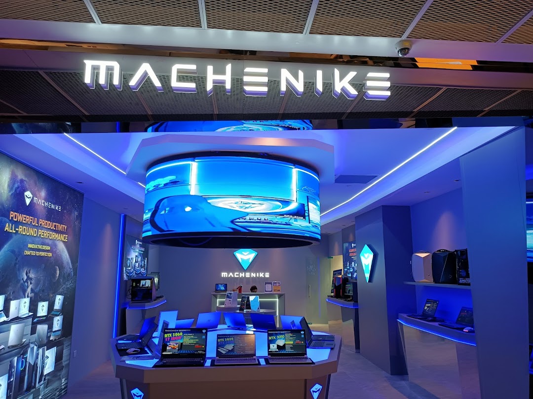 Interior view of the Machenike Experience Store showcasing gaming laptops, PCs, and a large curved display.
