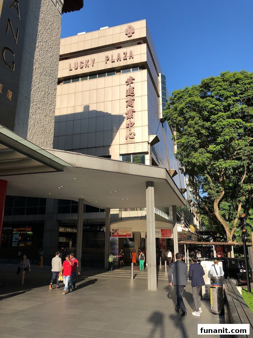 Exterior view of Lucky Plaza's entrance, showcasing the building facade and pedestrians.