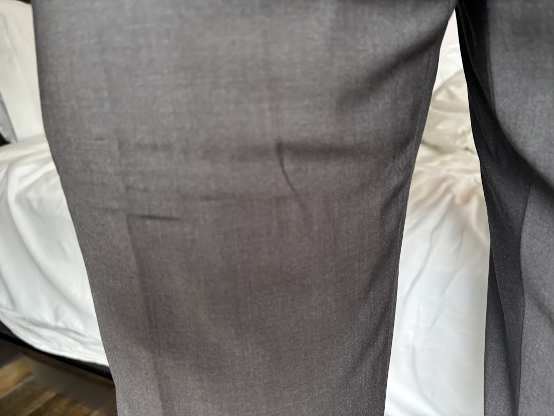 Close-up of dark grey trousers, showcasing fabric texture and potential tailoring or laundry quality.