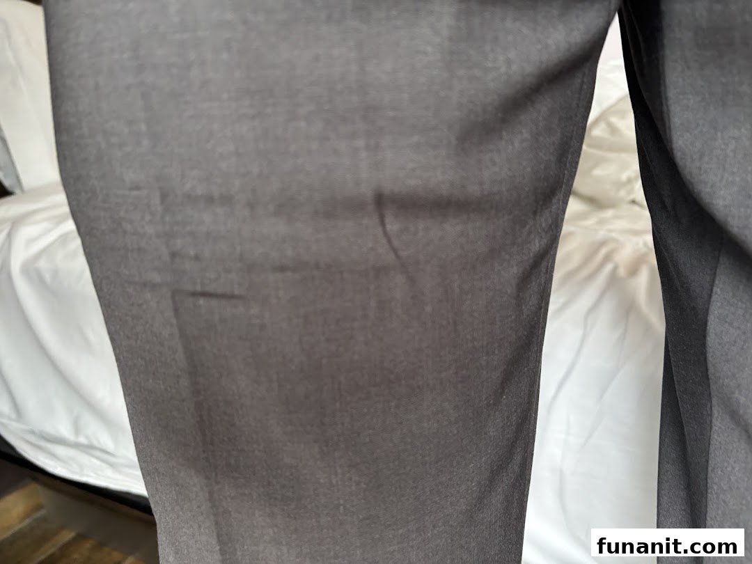 Close-up of dark grey trousers, showcasing fabric texture and potential tailoring or laundry quality.