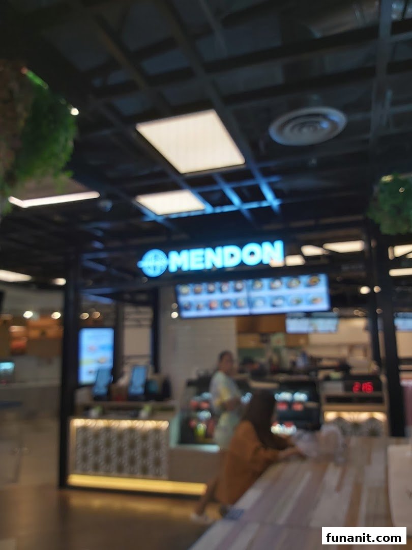 An interior view of Mendon, a food establishment, showing the counter, staff, and customers.