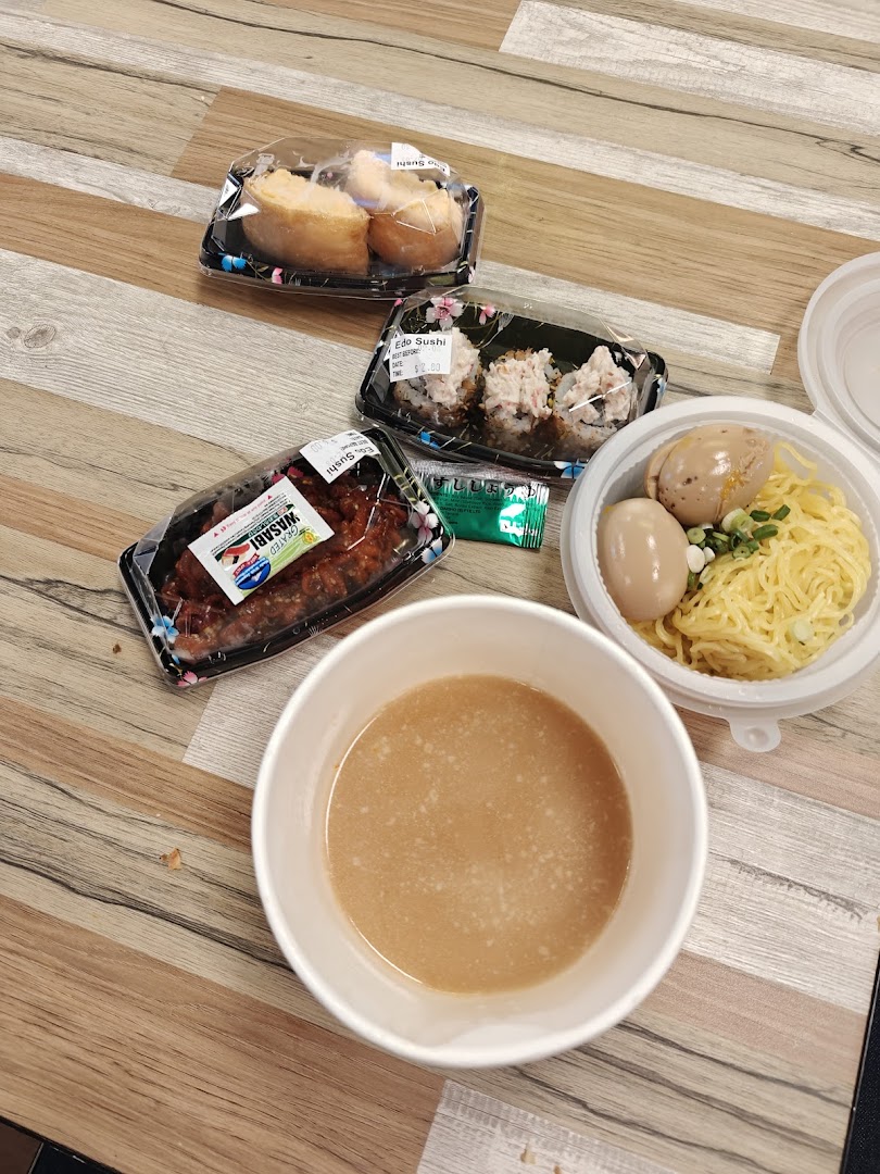 An assortment of delicious Japanese takeout, including sushi, noodles with eggs, and a savory soup.